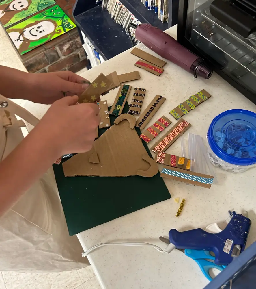 A child making a lion head out of cardboard