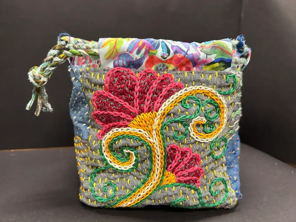 A colorful quilt bag with a flower pattern