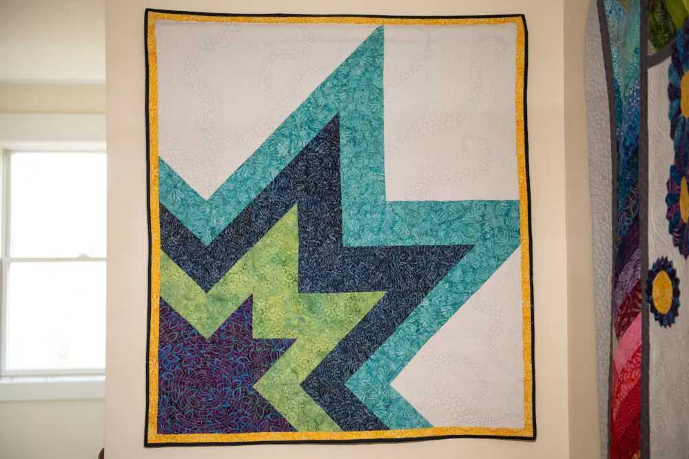 A quilt with half of a diamond coming out of the lower left corner