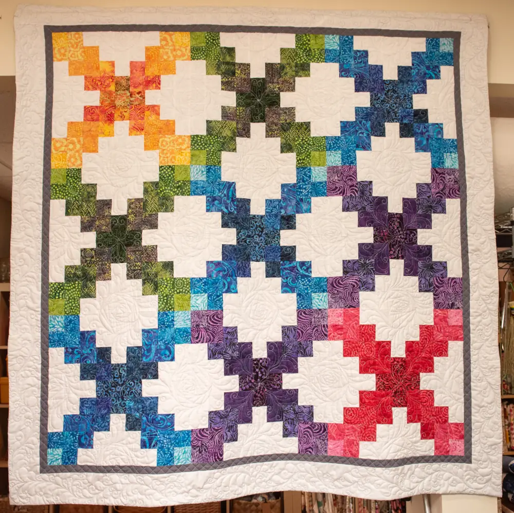 White quilt with pixelated X's of different colors