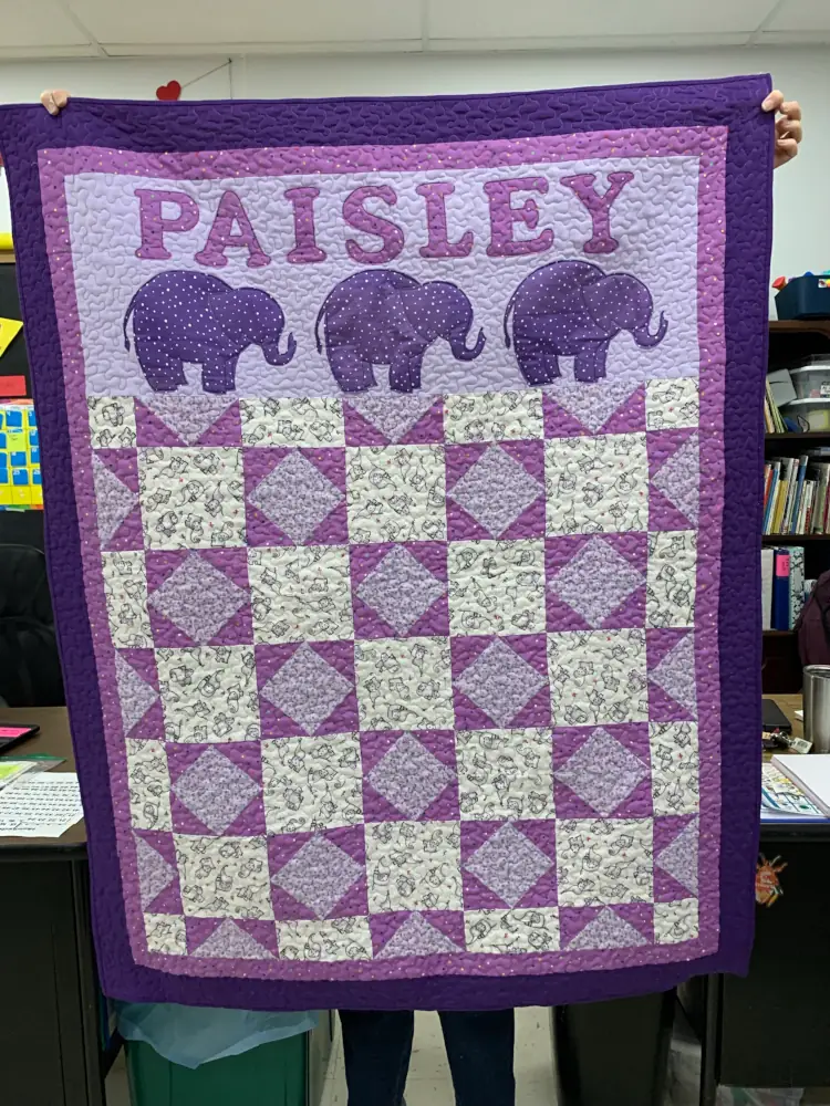 purple baby quilt with the name Paisley above elephants