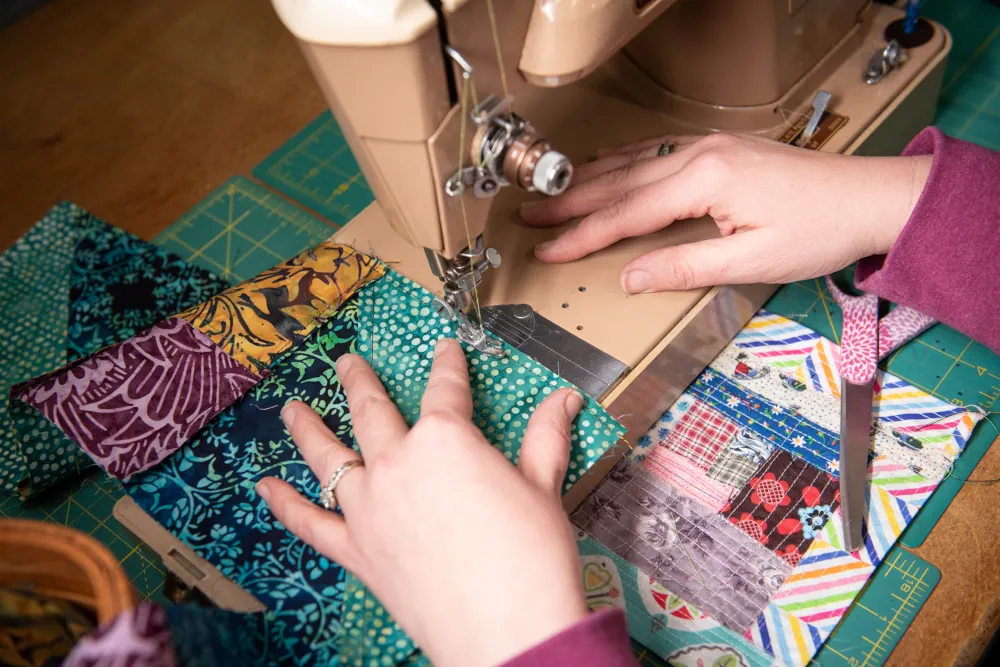 top down close up of someone using a sewing machine