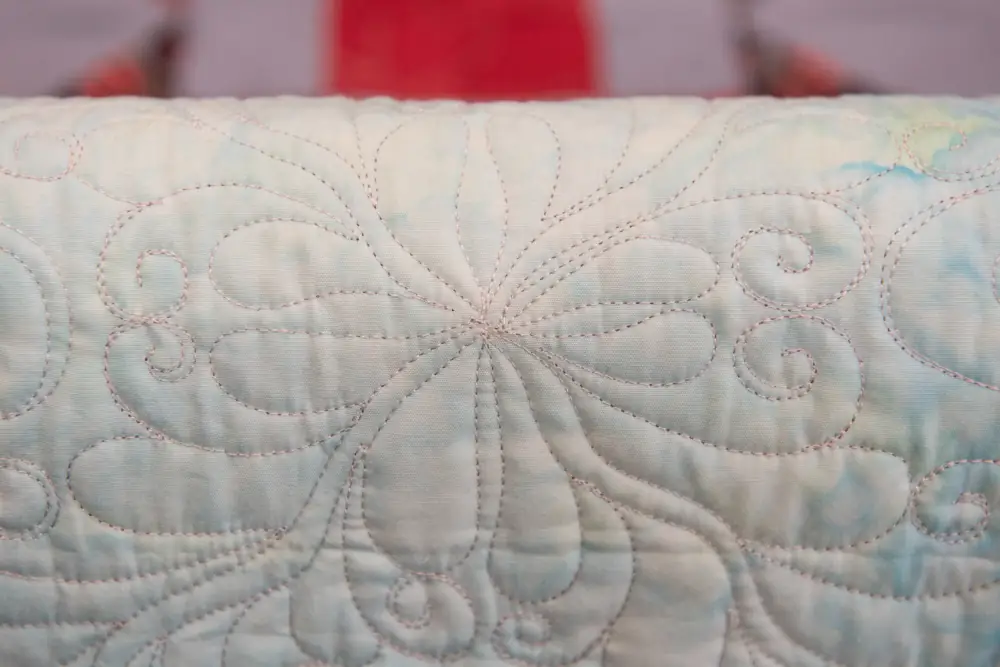 vintage white quilt with a flower design close up