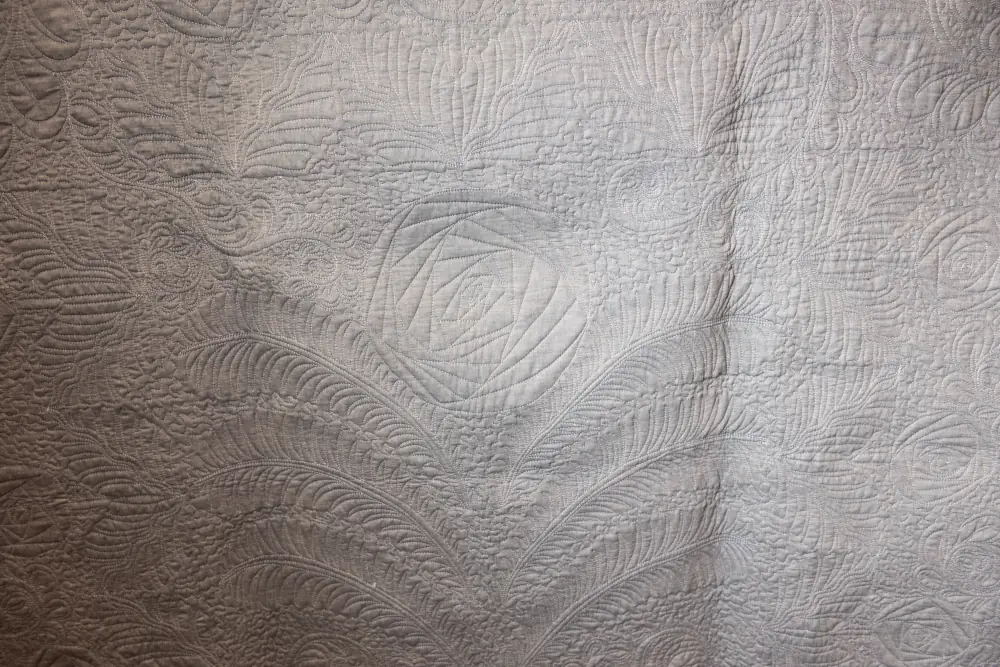 vintage white quilt with a flower design